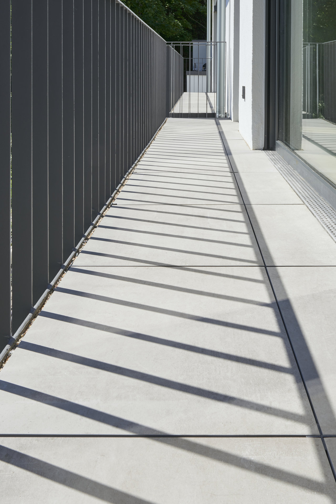 Helle Outdoor-Fliesen auf einem modernen Balkon mit elegantem Schattenwurf.