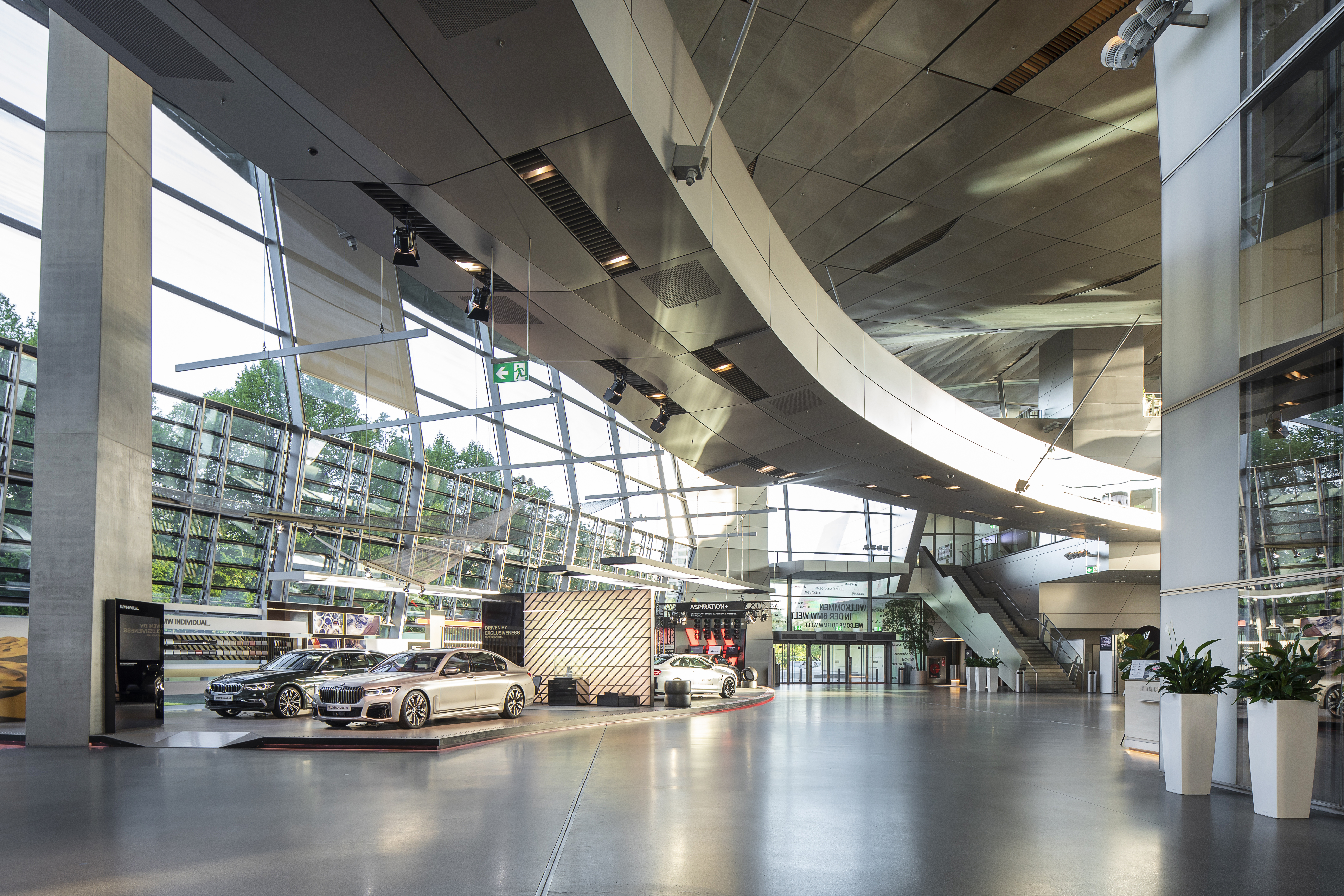 Eleganter Showroom mit hellem, großformatigem Fliesenboden und modernen Fahrzeugen.