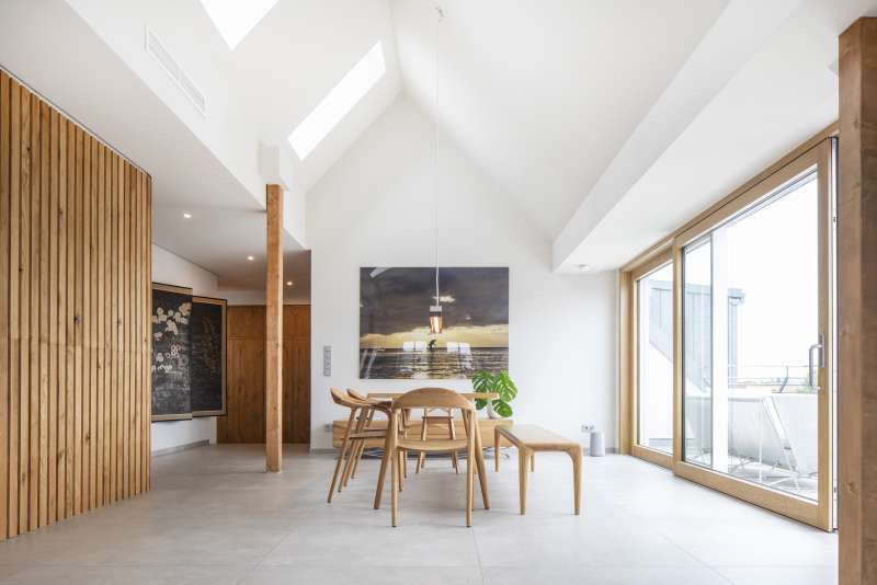 Geräumiger Essbereich mit hellen Bodenfliesen, Holzakzenten und viel Tageslicht.