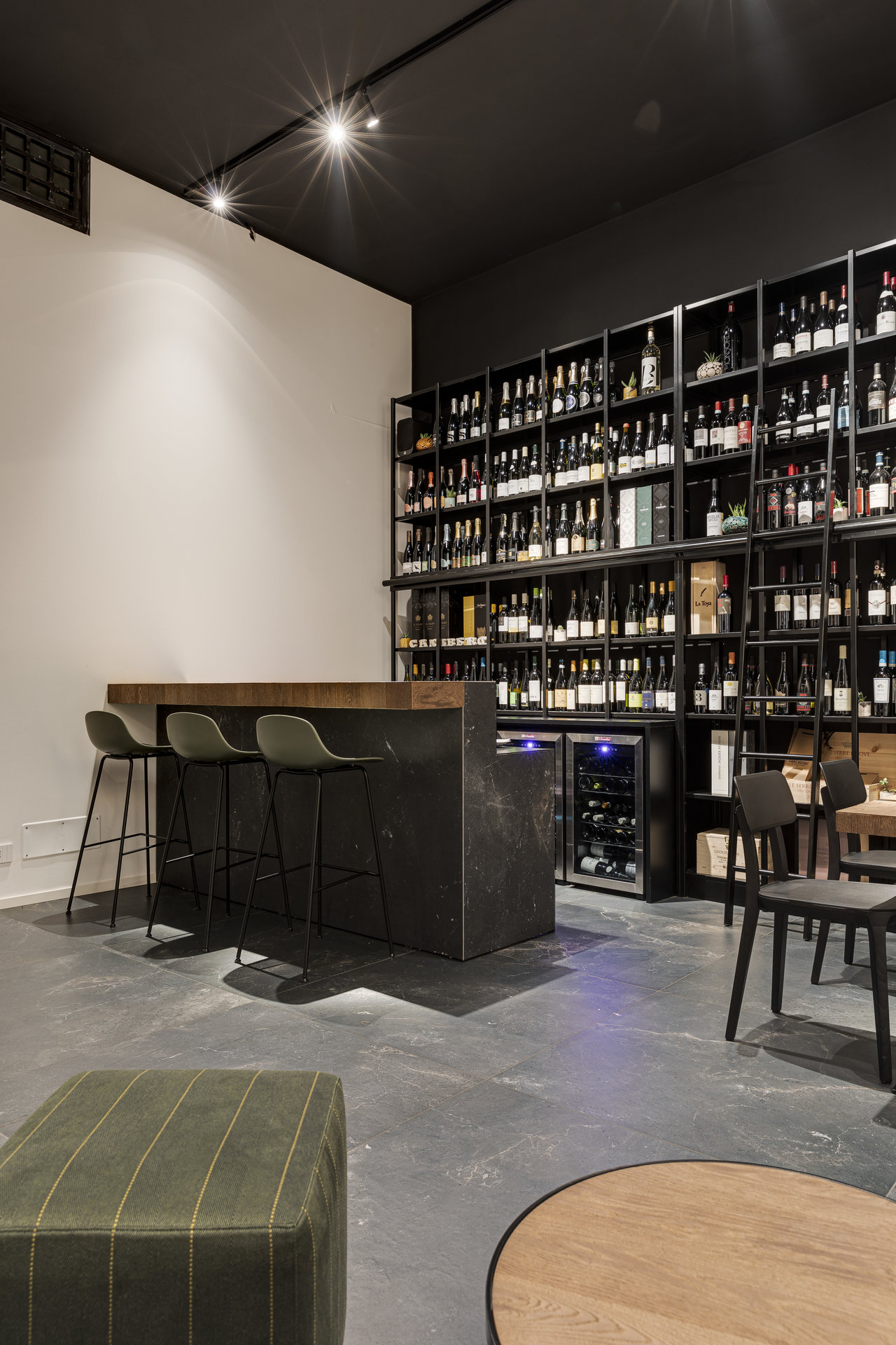 Elegante Weinbar mit großformatigen Fliesen in Betonoptik.