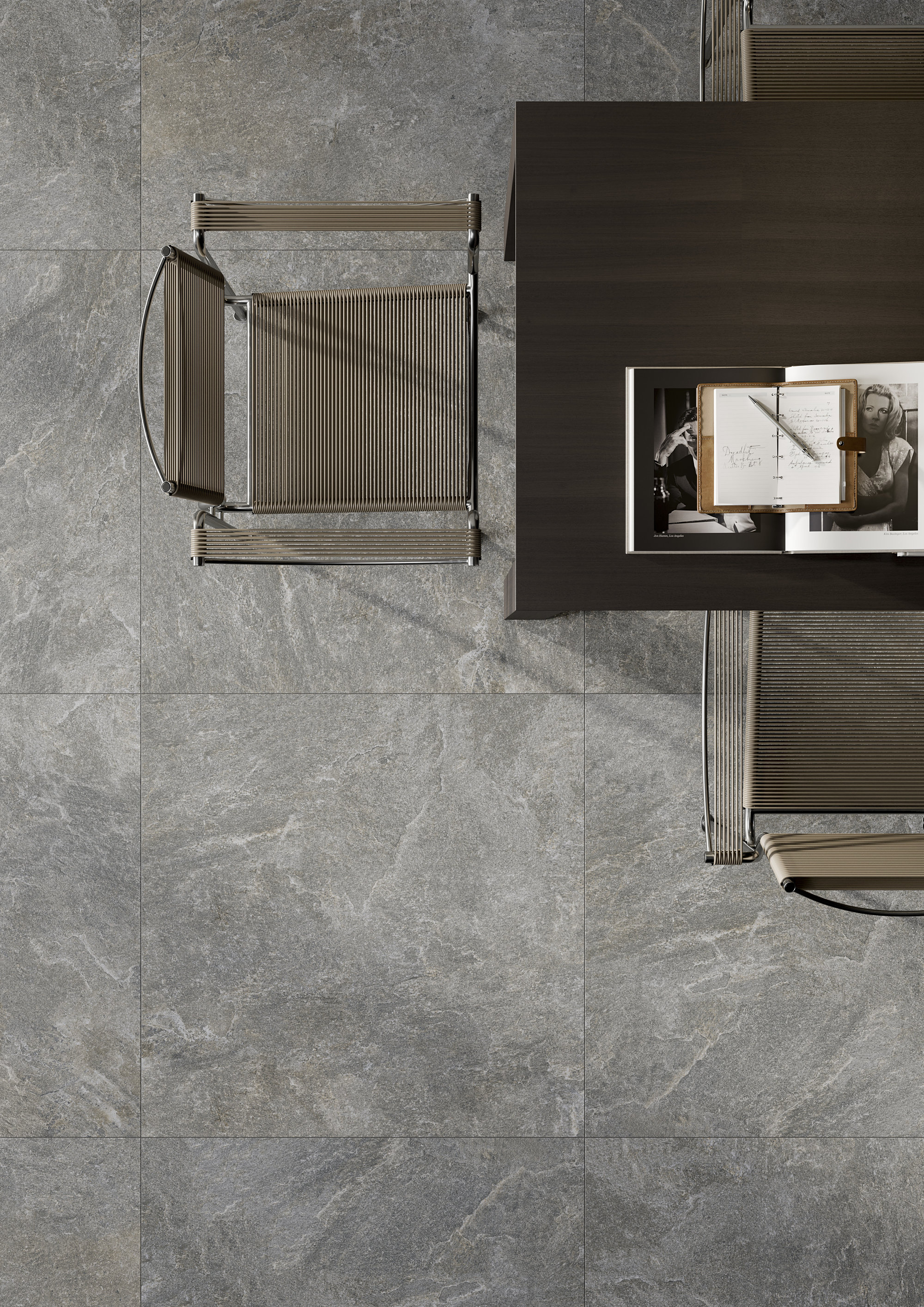 Graue Feinsteinzeugfliesen in Steinoptik, großformatig, mit dunklem Tisch.