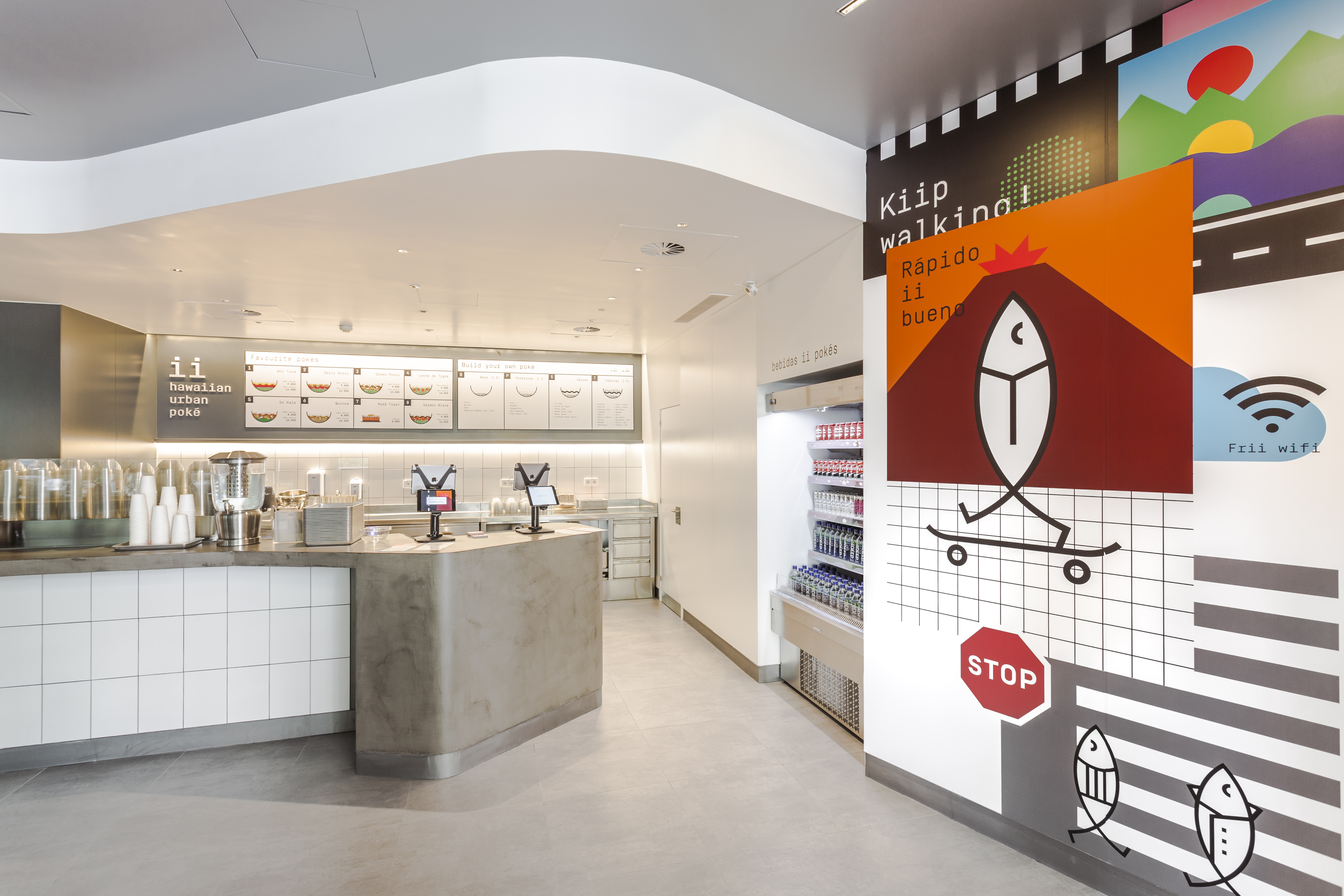 Modernes Café-Interieur mit hellgrauen Bodenfliesen und weiß gefliester Theke.